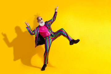 Full size photo of extravagant funny man dancing good mood empty space shiny costume isolated on yellow color background