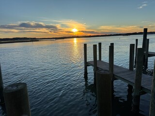 Wooden dock at golden sunset over quiet bay