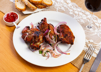 Traditional european dish Shashlik cordero - fried lamb kebab with onion on white plate