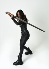Fantasy female warrior in leather armour  full body studio portrait of fierce brunette in catsuit...