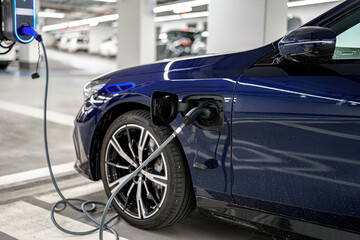 Electric vehicle charging in a modern parking garage during daytime hours
