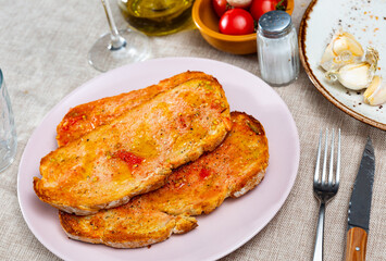 Slices of fragrant white bread covered with thin layer of tomato puree are complemented with slices...
