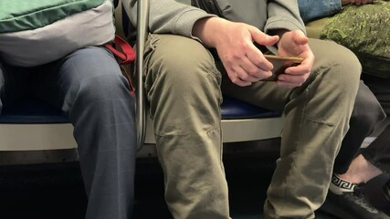Passengers on the subway seem to be deeply engrossed in their smartphones, vividly showcasing modern commuting habits.
