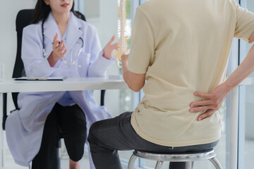 Doctor Explaining Spinal Issues to Patient with Back Pain