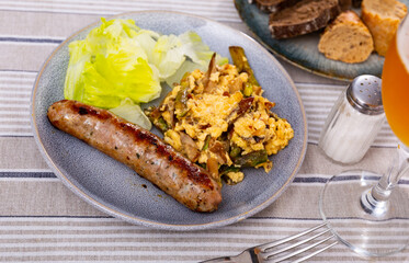 Delicious scrambled eggswith wild mushrooms and champignons with sausages