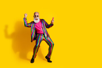 Full body portrait of eccentric man hold smart phone raise fist empty space shiny costume isolated on yellow color background
