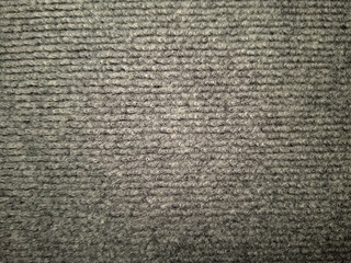 Coarse, textured fabric surface with a pattern of horizontal lines and a mix of light gray and dark gray shades creating a natural, woven look. No visible text or distinct markings