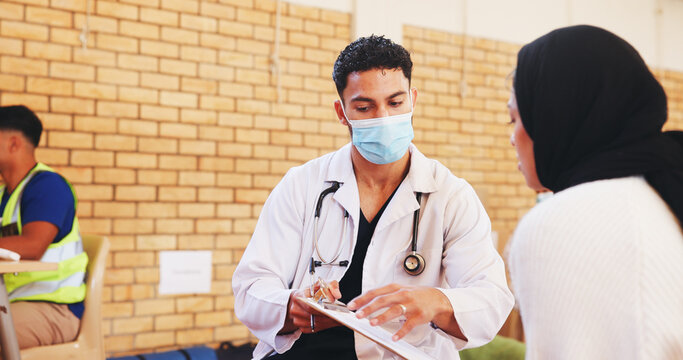 Clipboard, doctor and face mask with man in community center for healthcare checkup. Documents, insurance or volunteer with medical professional and patient at outreach event for charity or medicare