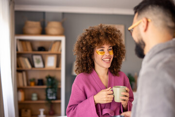 Smiling Couple in Bathrobes Enjoying Coffee Indoors with Relaxed Morning Vibes