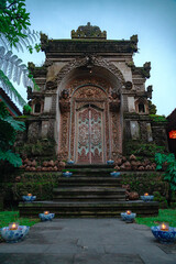Carved entrance to a temple in Bali decorated for the holiday in the evening