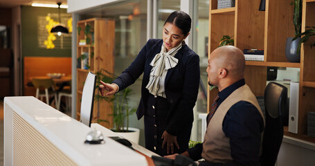 Fototapeta na wymiar Man, woman and concierge with mentor at hotel with computer, point and discussion for booking info. People, training and receptionist with listening with pc for hospitality with coach at lodge
