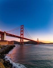 Fototapeta premium Iconic Golden Gate Bridge at Sunset in San Francisco, California, USA Breathtaking View with Orange Hues and Calm Water