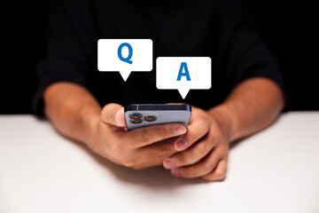 A person holding a smartphone with floating Q and A chat bubbles, symbolizing questions and answers...