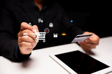 Person holding a credit card and interacting with digital shopping icons above a tablet, representing online shopping and e-commerce.