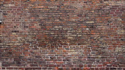 Weathered red brick wall creating an old and textured background, ideal for design projects