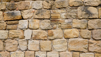 Background of an old sandstone wall with different sized and shaped blocks, perfect for photo textures