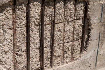 rust and oxidized metal on a building with reinforced concrete structure. facade restoration, corroded iron bars, involves application of anticorrosive on the structural lesions of the retaining wall.