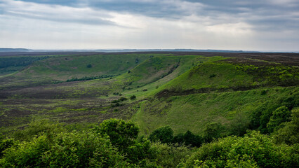 Naklejka premium Breathtaking landscape showing the beauty of nature in North York Moors National Park, UK, with its green hills and valleys under a cloudy sky
