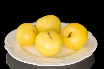 Yellow juicy plums isolated on black background, close-up.