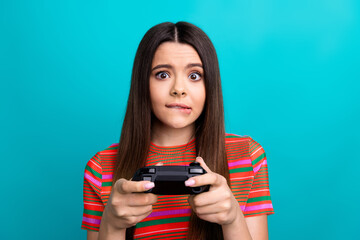 Young woman playing video games with intense focus against a vibrant teal background
