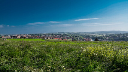Obraz premium Panoramic view of Whitby from a green meadow in the North York Moors National Park, United Kingdom