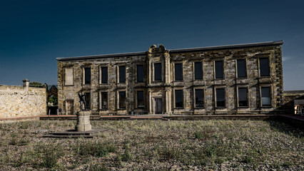 Fototapeta premium Whitby Abbey house facade with statue in the foreground, located in Whitby, North York Moors National Park, UK, on a sunny day with blue sky