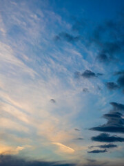 Vertical cloudscape at sunset early in May, southwest Florida, with high diaphanous clouds in the distance and darkening cloudlets in foreground. Motifs of duality, transition, and change in nature.