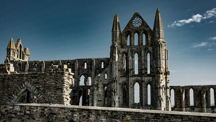 Whitby Abbey's gothic ruins stand tall against a clear blue sky, a testament to history and...