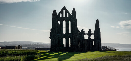 Fototapeta premium Majestic ruins of Whitby Abbey silhouetted against the sky, a captivating landmark in North York Moors National Park, UK
