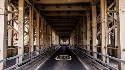Empty road running through the Tyne Bridge in Newcastle upon Tyne, England, with speed limit sign and metal structure