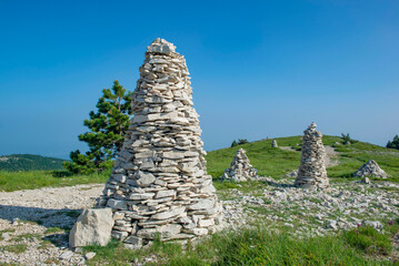 large mountain cairns iat the edge of a path n a beautiful landscape under blue sky in the Lure mountain in the Vaucluse in France