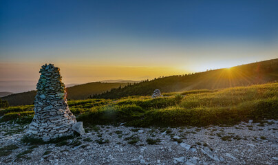 a large mountain cairn in a beautiful landscape during a sunset  in colorful sky in the Lure mountain in the Vaucluse in France