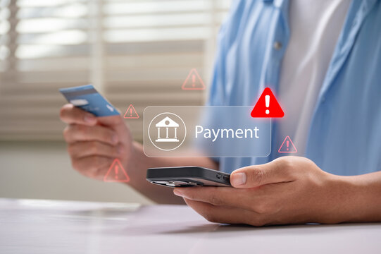 Online payment fraud warning during mobile transaction as man uses credit card and smartphone for digital banking, facing potential fraud, phishing, and cybersecurity threats in financial transactions