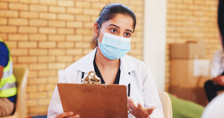 Clipboard, consulting and face mask with doctor in community center for healthcare checkup. Documents, insurance and volunteer with medical professional at outreach event for charity or medicare