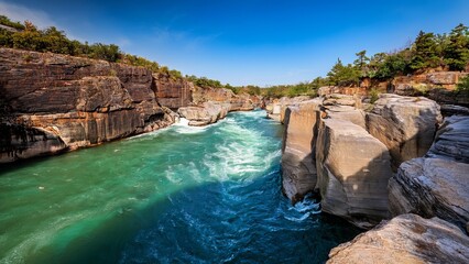 Majestic River Canyon Landscape with Turquoise Water Flowing Through Rocky Walls Under a Clear Blue Sky - Nature's Beauty
