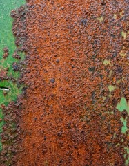 Detailed close-up of rusty metal texture showing corrosion with green background, weathered surface, aged iron, and oxidizing steel for industrial design and abstract art