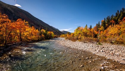 Stunning Scenic View of a River Valley in Autumn with Vibrant Foliage, Blue Sky, and Mountain Landscape in Bright Sunlight
