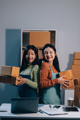 Startup SME small business entrepreneur of freelance Asian woman wearing apron using laptop and box...