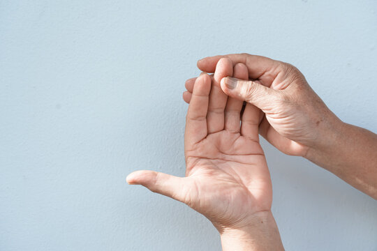 A woman uses her other hand to feel pain and tingling. along with Guillain-Barre syndrome and numbness in the hands Elderly woman tries to massage herself to relieve wrist pain