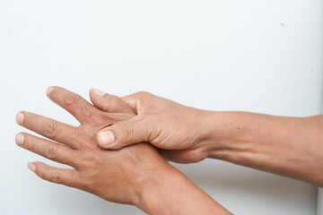 A man uses his other hand to feel pain and tingling, along with Guillain-Barré syndrome and numbness in his hand. An elderly man tries to massage himself to relieve the pain in his wrist.