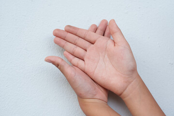 The boy is gesturing on a white background.