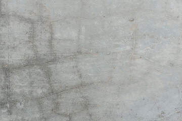 A close-up view of a cracked concrete surface, showcasing irregular fissures and the texture of the...