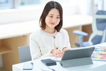 室内で仕事をするスーツ姿の女性