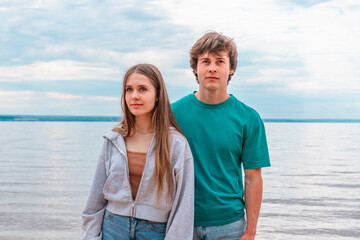 A date on the beach for a young couple, a teenage girl and a boy walking in the evening, first love...