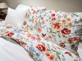 Cozy bedding with floral print in a serene bedroom setting during daytime