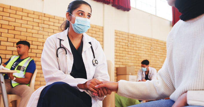 Face mask, support and doctor holding hands with patient for charity, NGO campaign and counselling. Outreach event, nurse and person in community center with healthcare volunteer, advice and help - Powered by Adobe