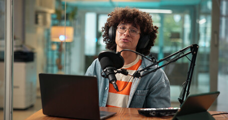Portrait, man and headphones with mic for broadcast, recording podcast and reporter in studio. Male...