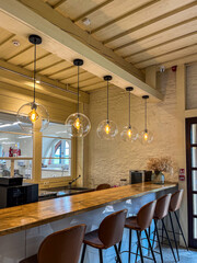 Stylish cafe interior featuring pendant lights and a wooden counter in a cozy atmosphere