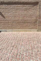 Old yellow brick wall and cobblestone floor