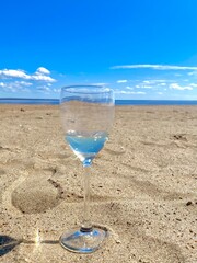 A glass of pesto on the beach. A cocktail in a glass. The sky is in the glass.